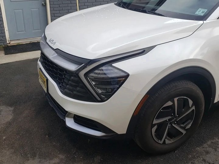 After: the same white Kia Sportage with the front end rebuilt and repainted