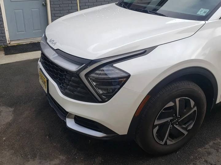 After: the same white Kia Sportage with the front end rebuilt and repainted